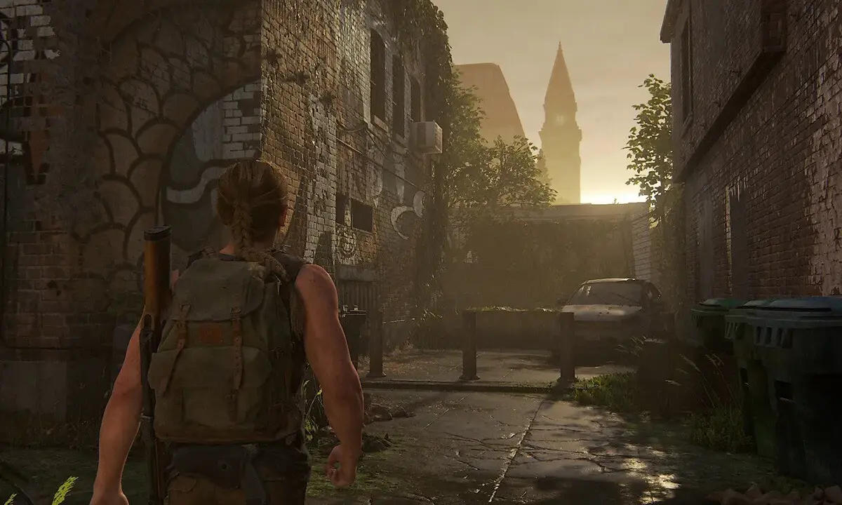 Abby camina por una calle desolada, reflexionando sobre cuanto dura The Last of Us 2. El sol se pone tras una torre.