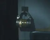 Caja fuerte de combinación en la oficina oeste de Resident Evil 2. Las letras visibles son F, D, N y A, E, O.