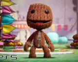Sackboy, personaje de juegos plataformas PS5, posa con banderas coloridas de fondo.