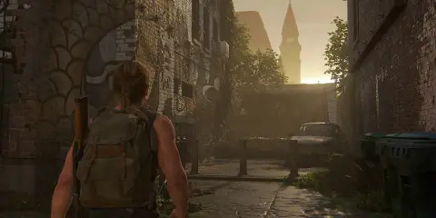 Abby camina por una calle desolada, reflexionando sobre cuanto dura The Last of Us 2. El sol se pone tras una torre.