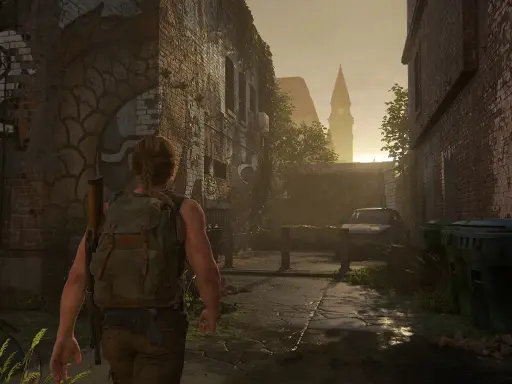 Abby camina por una calle desolada, reflexionando sobre cuanto dura The Last of Us 2. El sol se pone tras una torre.