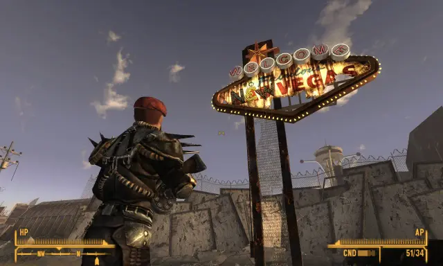 Un personaje con armadura improvisada mira el icónico letrero "Welcome to Fabulous Las Vegas" en un páramo desolado, típico de Fallout New Vegas.