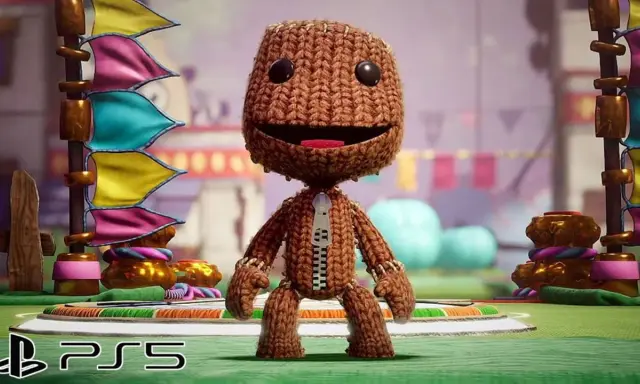 Sackboy, personaje de juegos plataformas PS5, posa con banderas coloridas de fondo.
