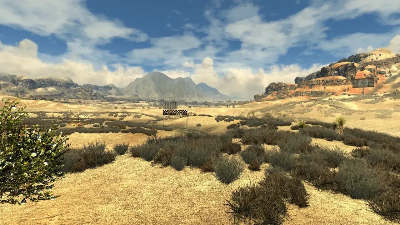 Paisaje desértico con montañas al fondo y una meta de carreras. Un vistazo a Fallout New Vegas Remastered.